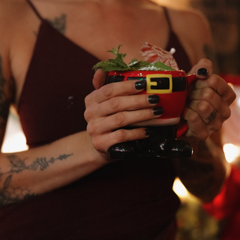 Miracle Pop Up at Killjoy - A Woman Holding a Drink in a Santa Cup